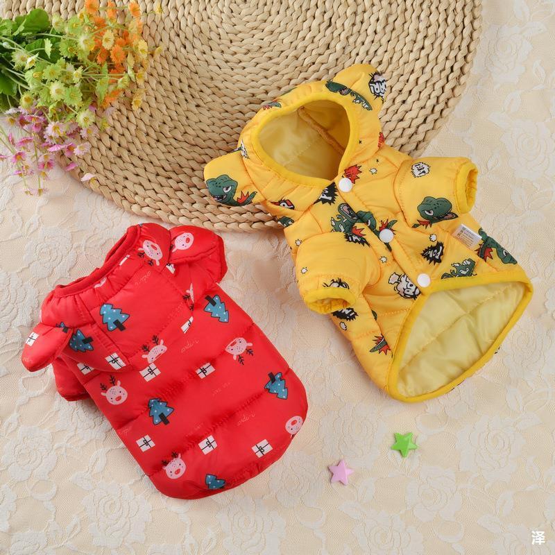 Red and yellow dog coats with cartoon patterns on a textured surface.
