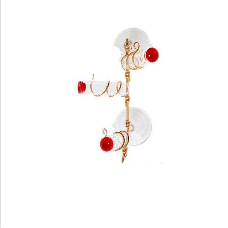 Garden Bird Feeder with transparent tubes and red caps attached to gold metal spiral frame