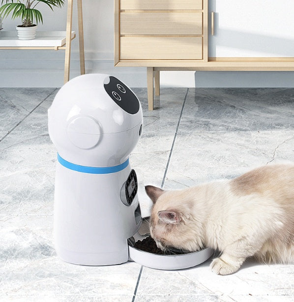 White Smart Pet Food Dispenser serving food to a cat eating from the attached bowl on a tiled floor