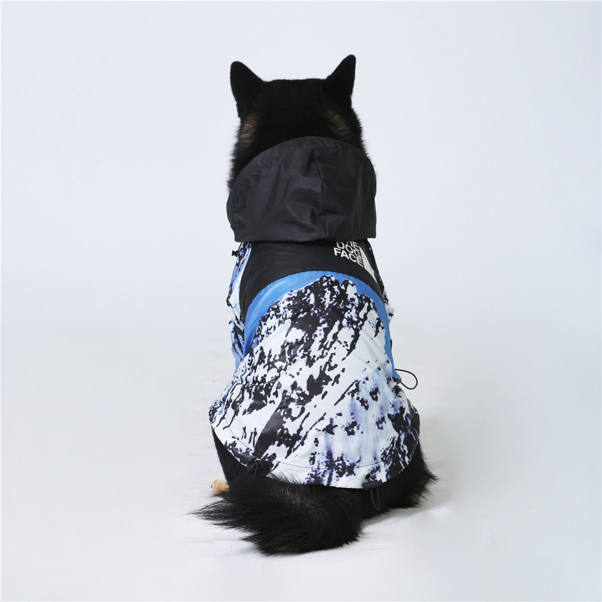 Furfamilyclub windproof dog jacket on black dog from rear with hood and blue white mountain print