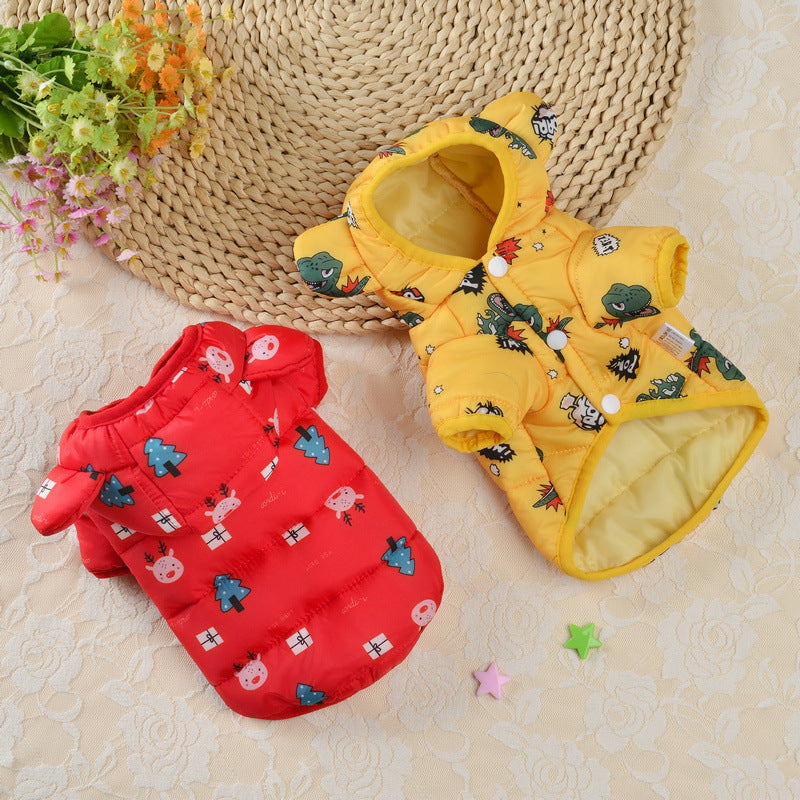 Red and yellow pet coats with cartoon designs on a textured surface.