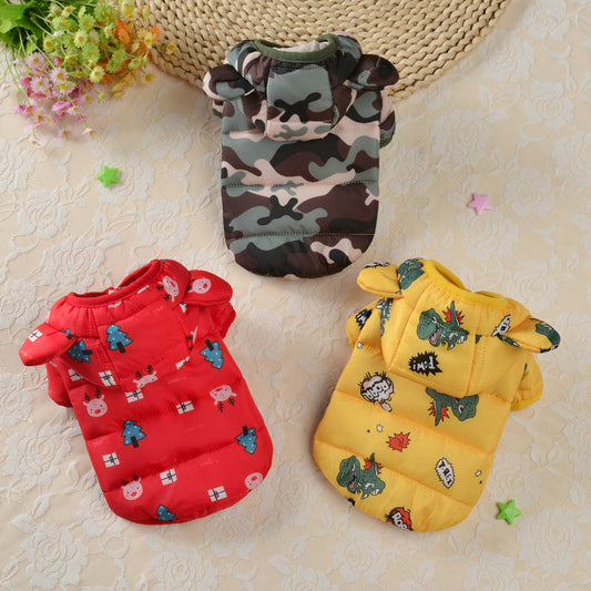 Three colorful pet coats with patterns on a textured surface.