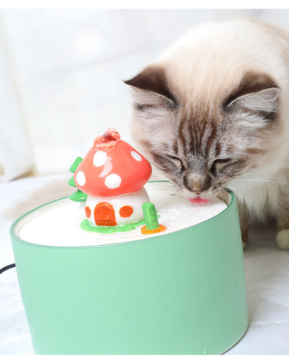 Cat drinking from a green automatic pet water dispenser with mushroom-shaped fountain
