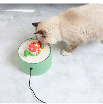Cat drinking water from a green automatic pet water dispenser with mushroom design